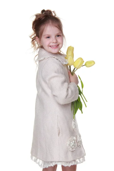 Linda niña en un abrigo sosteniendo un ramo de tulipanes —  Fotos de Stock