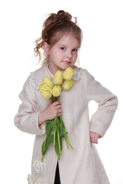 Schattig klein meisje in een vacht met een boeket van tulpen — Stockfoto