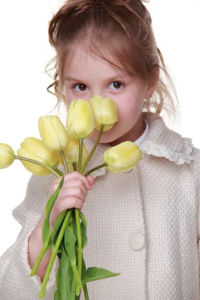 Petite fille mignonne dans un manteau tenant un bouquet de tulipes — Photo