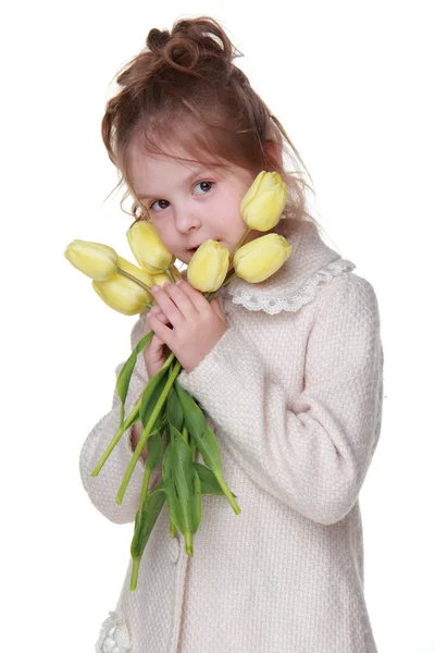 Niedliches kleines Mädchen im Mantel mit einem Strauß Tulpen — Stockfoto