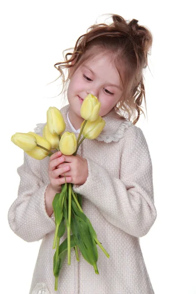 可爱的小女孩，在一件外套，拿一束郁金香 — 图库照片