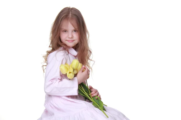 Cute little girl in a dress with a bouquet of tulips — Stock Photo, Image