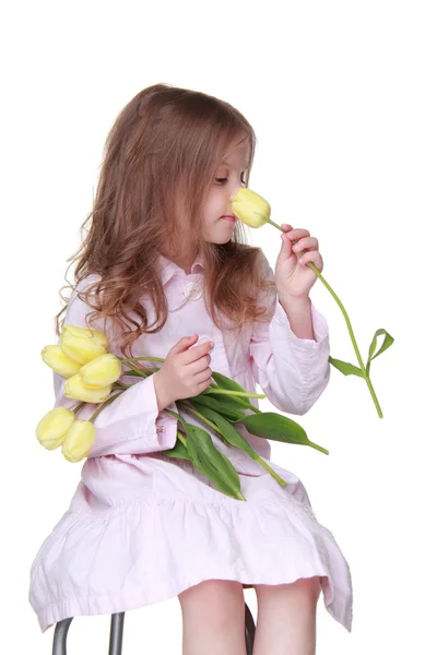 Cute little girl in a dress with a bouquet of tulips — Stock Photo, Image