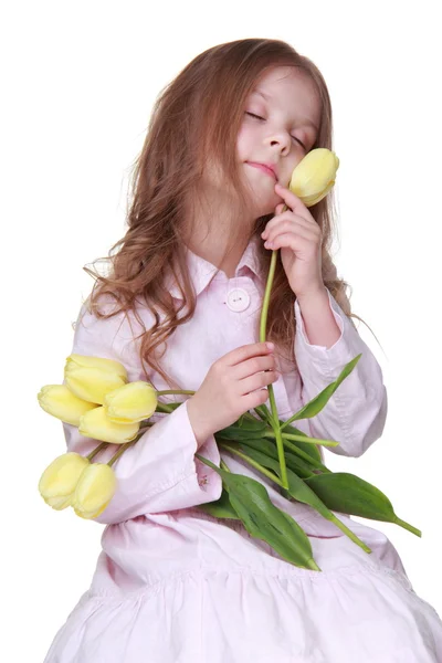 Cute little girl in a dress with a bouquet of tulips — Stock Photo, Image