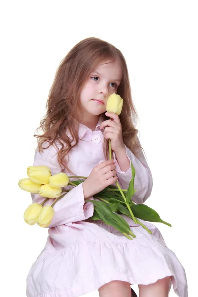 Linda niña en un vestido con un ramo de tulipanes — Foto de Stock