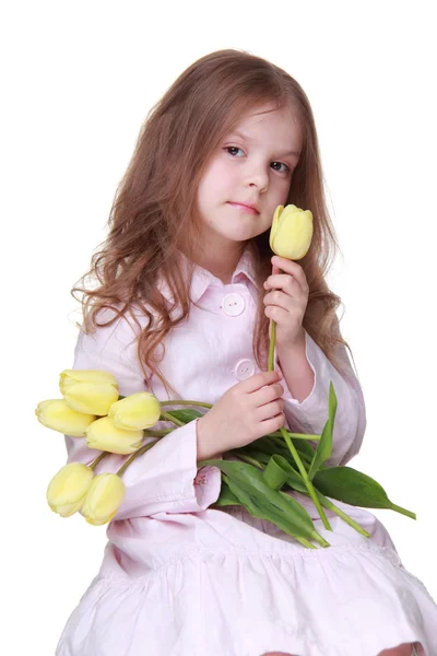 Schattig klein meisje in een jurk met een boeket van tulpen — Stockfoto