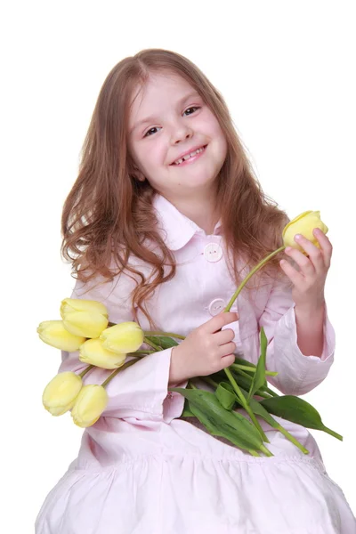 Schattig klein meisje in een jurk met een boeket van tulpen — Stockfoto