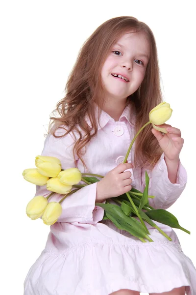 Schattig klein meisje in een jurk met een boeket van tulpen — Stockfoto