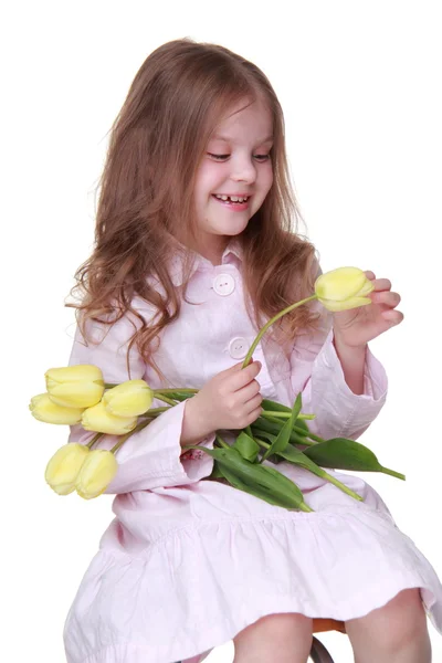 Милая маленькая девочка в платье с букетом тюльпанов — стоковое фото
