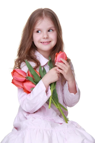 Linda niña en un vestido ligero con un ramo de tulipanes — Foto de Stock