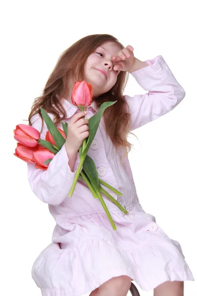 Niedliches kleines Mädchen in einem leichten Kleid mit einem Strauß Tulpen — Stockfoto