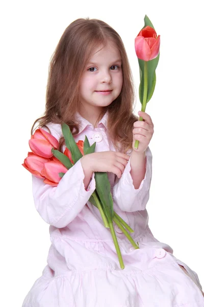 Schattig klein meisje in een lichte jurk met een boeket van tulpen — Stockfoto