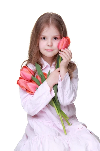 Schattig klein meisje in een lichte jurk met een boeket van tulpen — Stockfoto