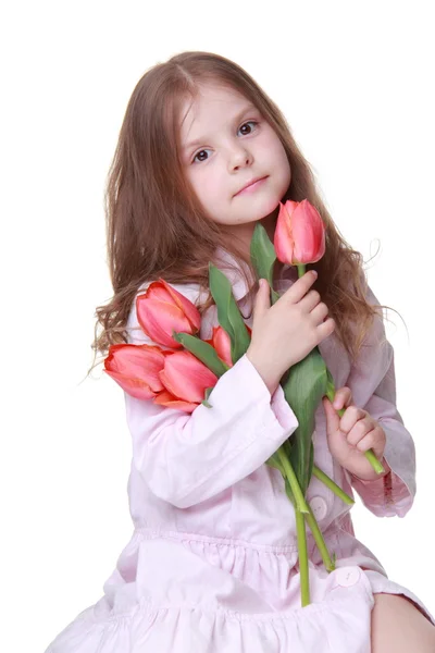 Cute dziewczynka w jasną suknię z bukietem tulipanów — Zdjęcie stockowe