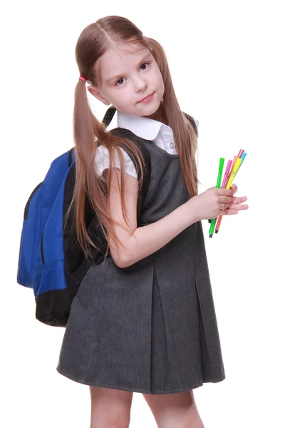 Studio portrait of girl with schoolbag holding felt-tip pens — Stock Photo, Image