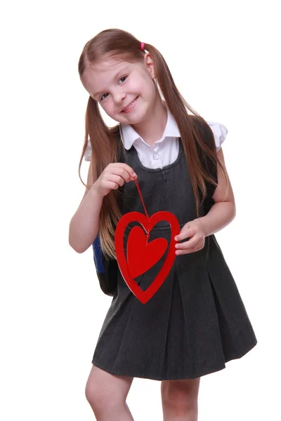 Caucasian lovely schoolgirl holding red heart symbol — Stock Photo, Image