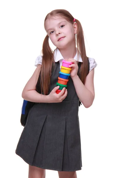Cute schoolgirl in dress holding paints — Stock Photo, Image
