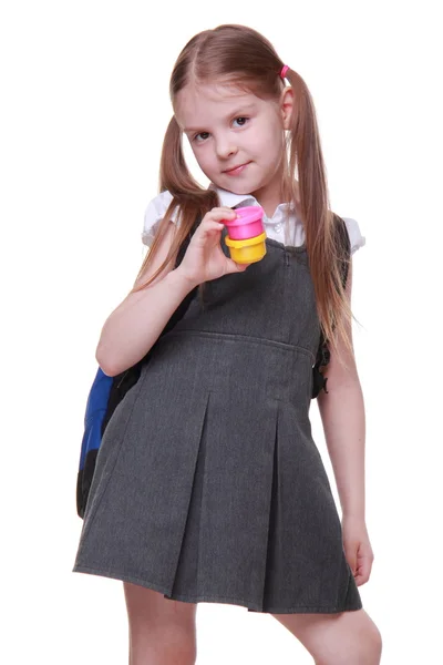 Мила школярка в сукні тримає фарби — стокове фото