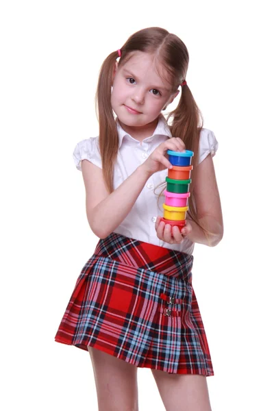 Cute girl in checkered skirt holding paints — Stock Photo, Image