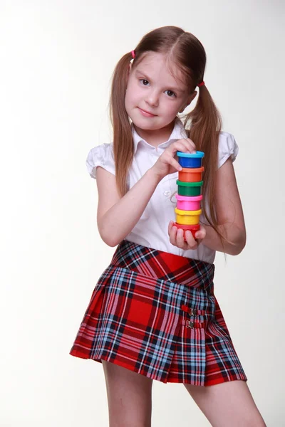 Cute girl in checkered skirt holding paints — Stock Photo, Image