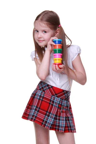 Cute girl in checkered skirt holding paints — Stock Photo, Image