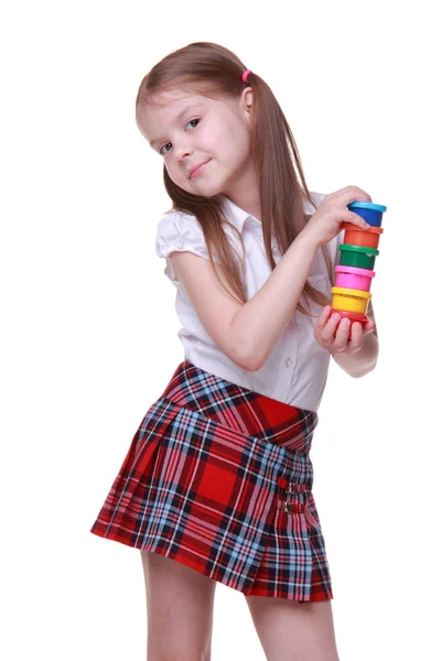 Cute girl in checkered skirt holding paints — Stock Photo, Image