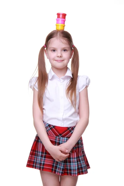 Cute little girl holding paints on her head — Stock Photo, Image