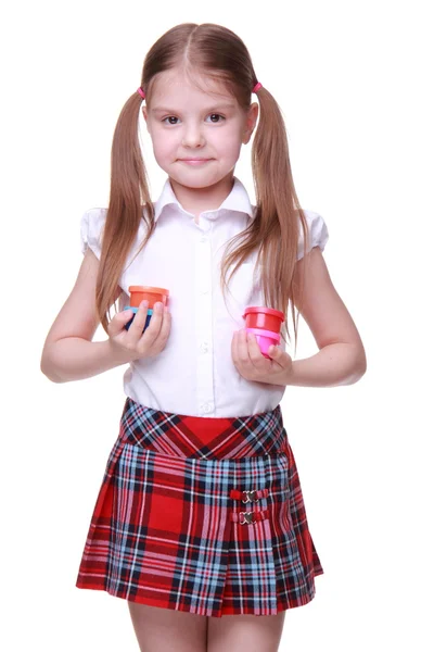 Cute girl in checkered skirt holding paints — Stock Photo, Image