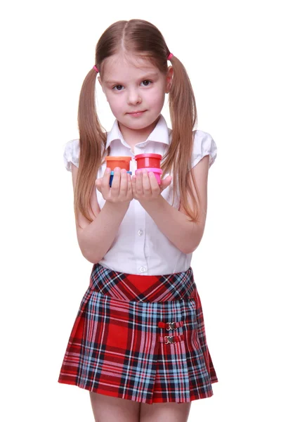 Cute girl in checkered skirt holding paints — Stock Photo, Image