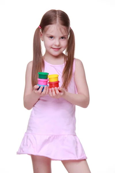 Cute little girl in pink dress holding paint — Stockfoto