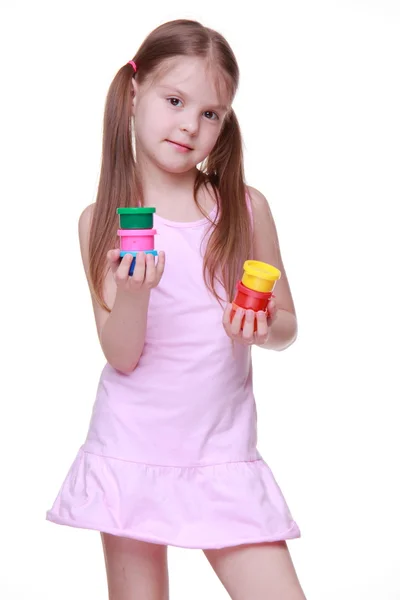 Cute little girl in pink dress holding paint — Stockfoto