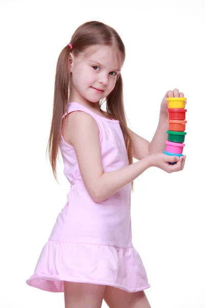 Cute little girl in pink dress holding paint — Stockfoto