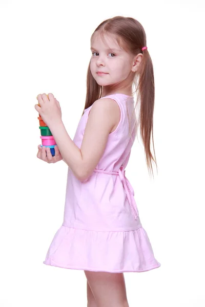 Милая маленькая девочка в розовом платье держит краску — стоковое фото
