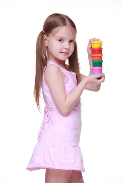 Cute little girl in pink dress holding paint — Stockfoto