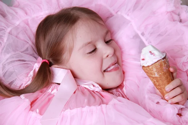 Linda chica en vestido rosa comiendo el helado —  Fotos de Stock