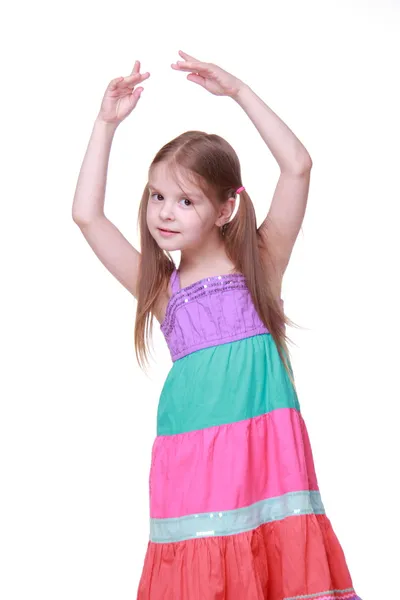 Красива маленька дівчинка в прекрасній барвистій сукні танцює в студії — стокове фото