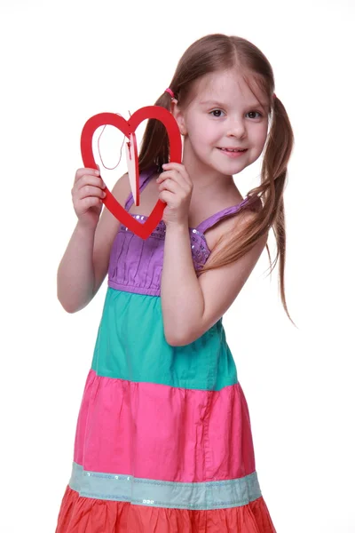 Niña en un vestido colorido posando con el corazón — Foto de Stock