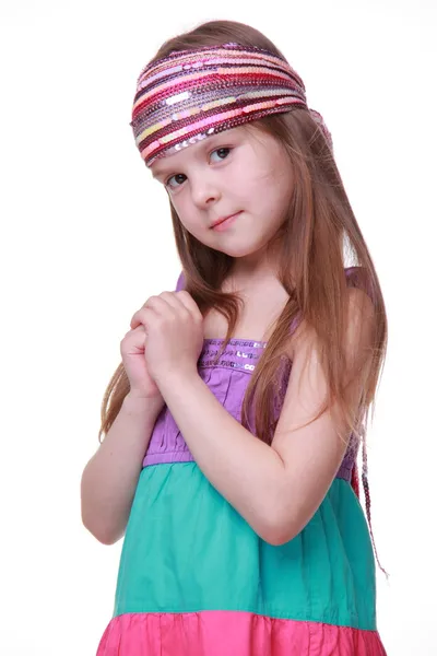 Маленькая девочка в красочном платье позирует в студии — стоковое фото