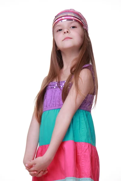 Bambina in un abito colorato in posa in studio — Foto Stock