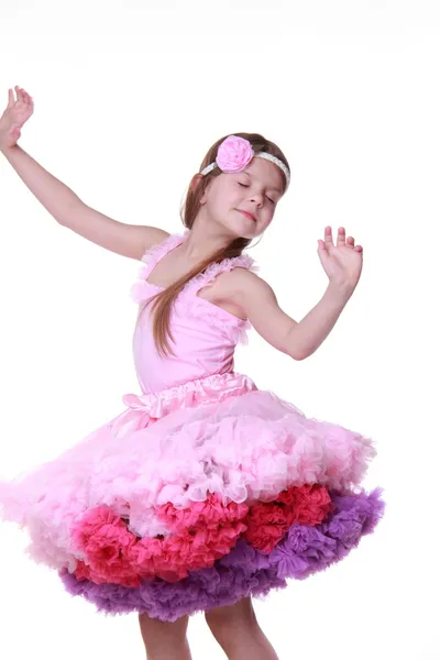 Beyaz bir arka plan üzerinde izole küçük kız dans pembe elbisenin içinde — Stok fotoğraf