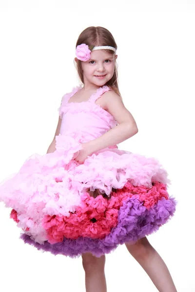 Beyaz bir arka plan üzerinde izole küçük kız dans pembe elbisenin içinde — Stok fotoğraf