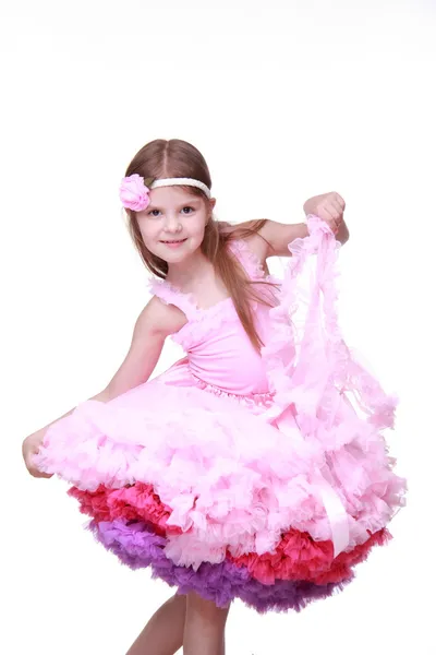 Bambina in abito rosa che balla isolata su uno sfondo bianco — Foto Stock