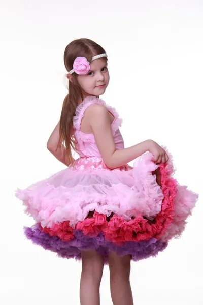 Bella bambina in un bel vestito rosa isolato su uno sfondo bianco — Foto Stock
