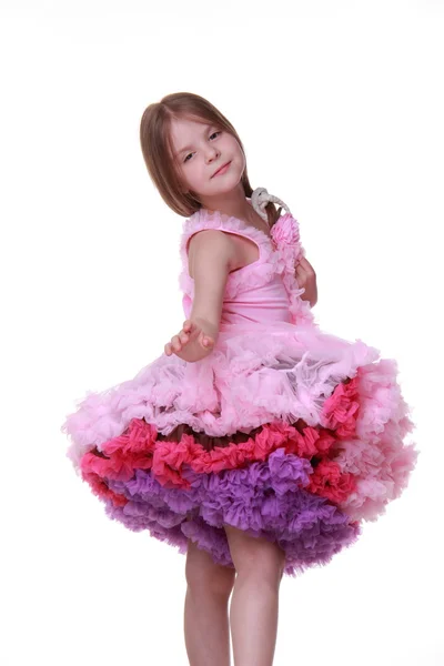 Bambina in abito rosa che balla isolata su uno sfondo bianco — Foto Stock