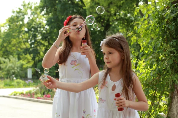Girls blows soap bubbles — Stock Photo, Image