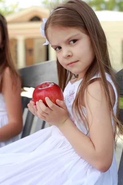 Belles filles avec panier de pommes rouges sur un banc — Photo