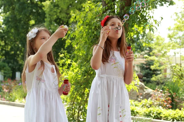 Girls blows soap bubbles — Stock Photo, Image