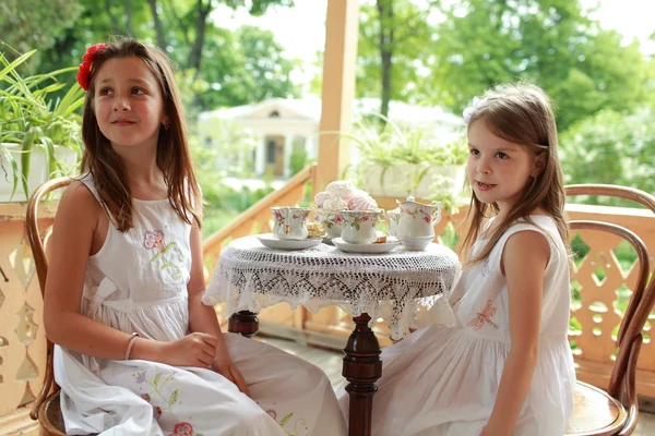 Outdoor image of beautiful little girls with tea — Stock Photo, Image