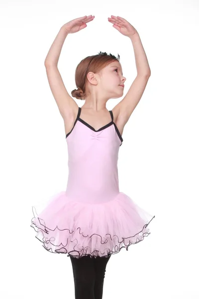 Roztomilá malá baletka s krásné vlasy stojí v baletní pozice — Stock fotografie