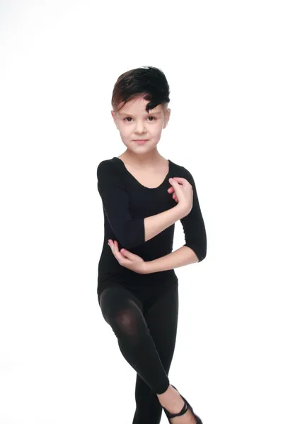 Bailarina joven Sonriendo pequeña bailarina de ballet en un traje negro en una pose de baile expresa las emociones de una danza — Foto de Stock